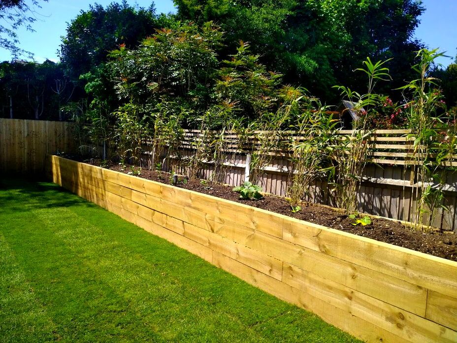 Timber raised bed along fence